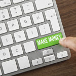 Man pushing "Make money" button on computer keyboard.